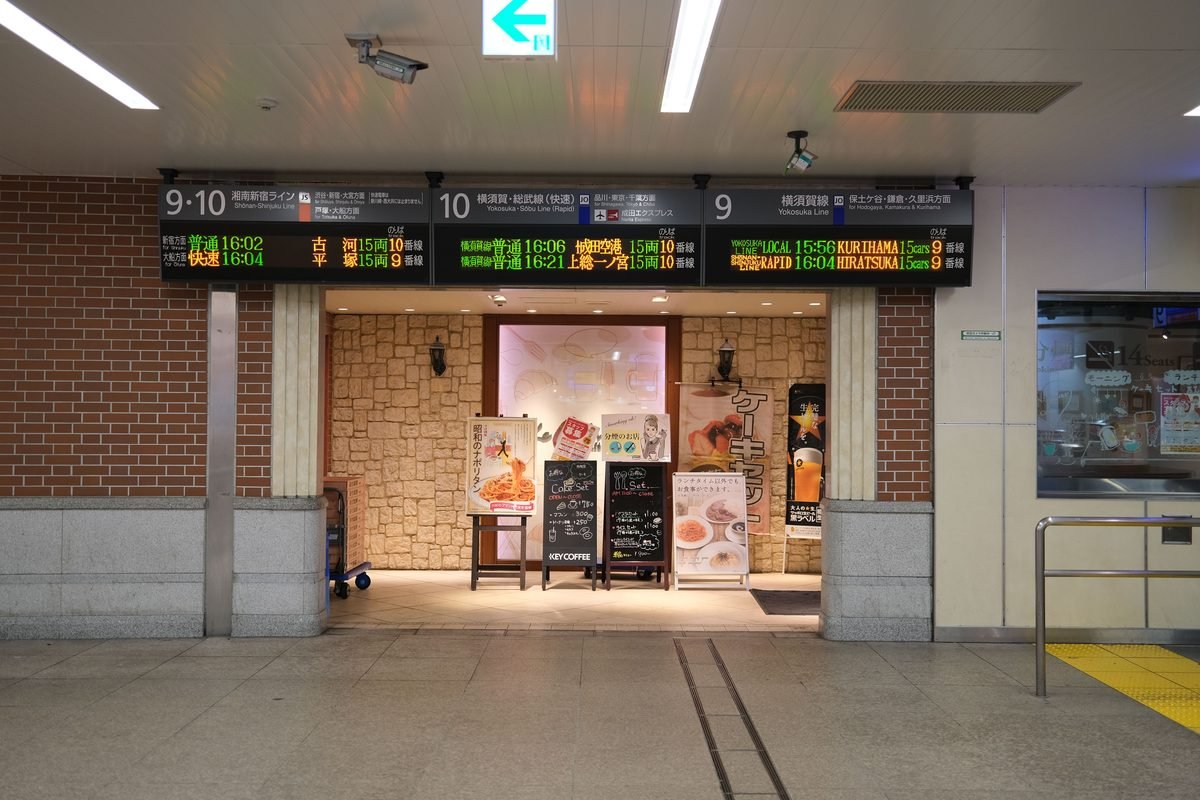 Digital train information boards above a station corridor in Yokohama