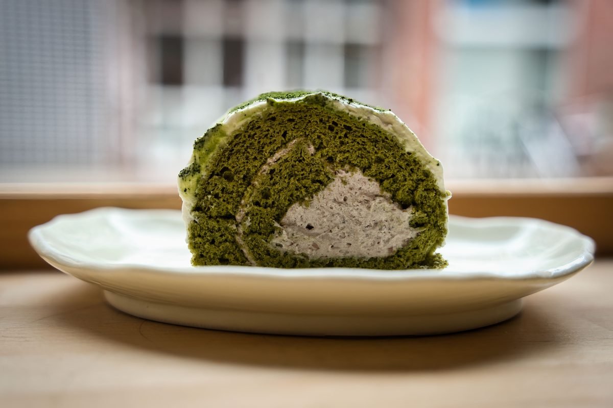 Matcha roll cake with cream filling on a white plate