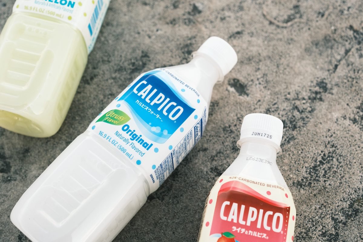 Calpico beverage bottles on textured concrete surface