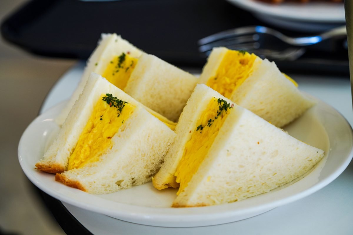 Egg salad sandwiches neatly arranged on a white plate