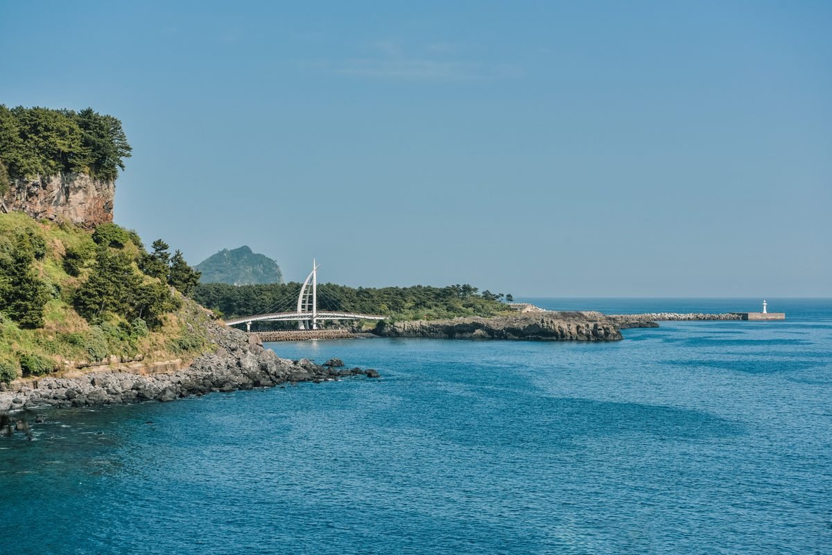 Coastal view of Jeju Island with clear blue waters and scenic cliffs