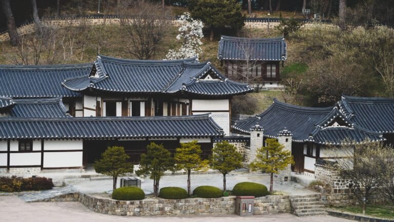 Elevated view of traditional Korean tiled roofs set against a natural hillside background.