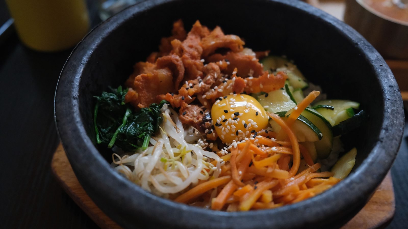 Sizzling Korean bibimbap served inside a traditional stone bowl.