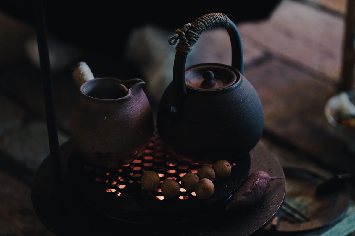 Ceramic kettles and cookware over an open flame