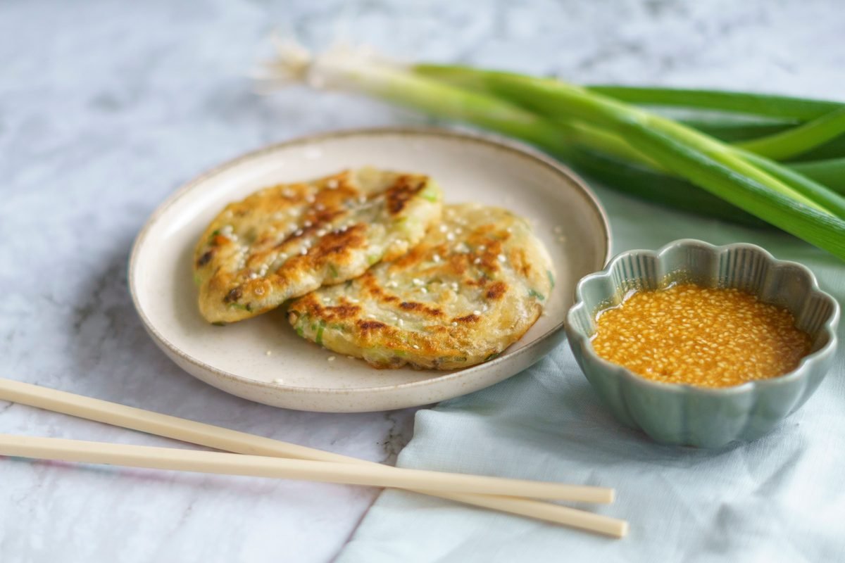 Korean scallion pancakes served with sesame dipping sauce on a ceramic plate