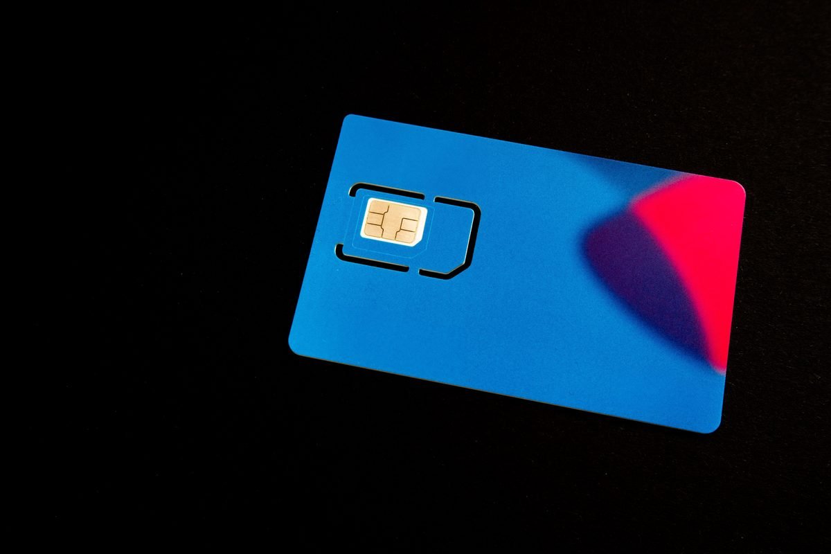 A blue SIM card on a dark background with vibrant accents