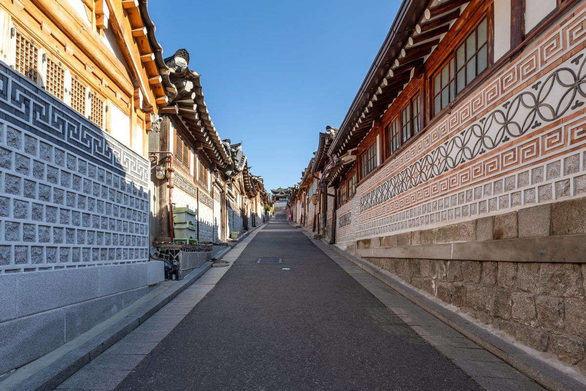 Bukchon-ro 11-gil street lined with traditional hanok houses in Seoul under blue sky.
