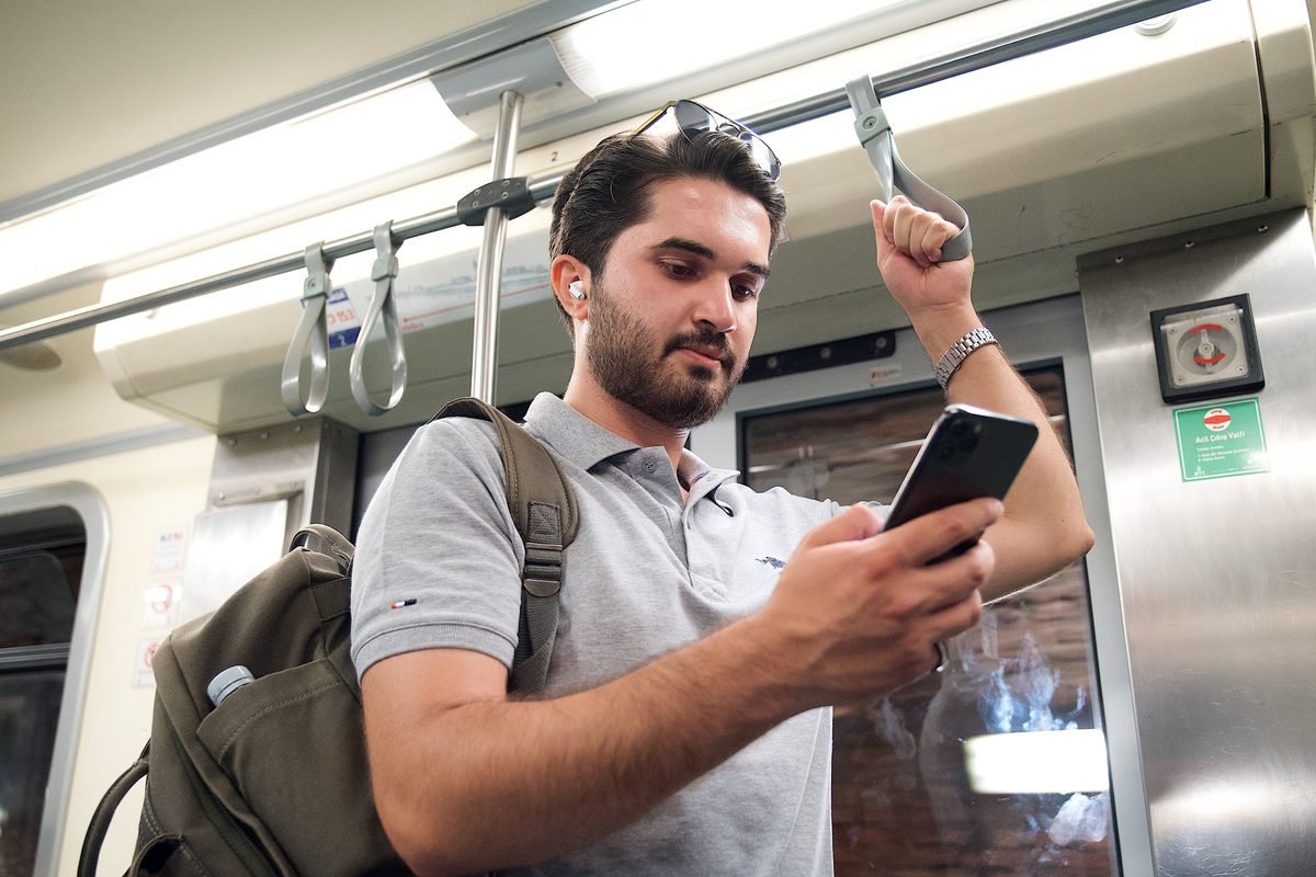 Commuter using smartphone on public transport.