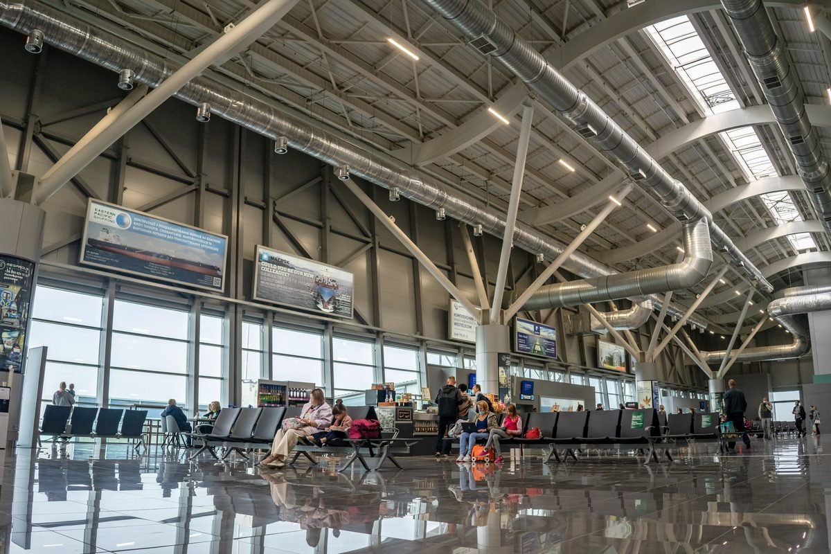 Spacious airport terminal interior with passengers seated.