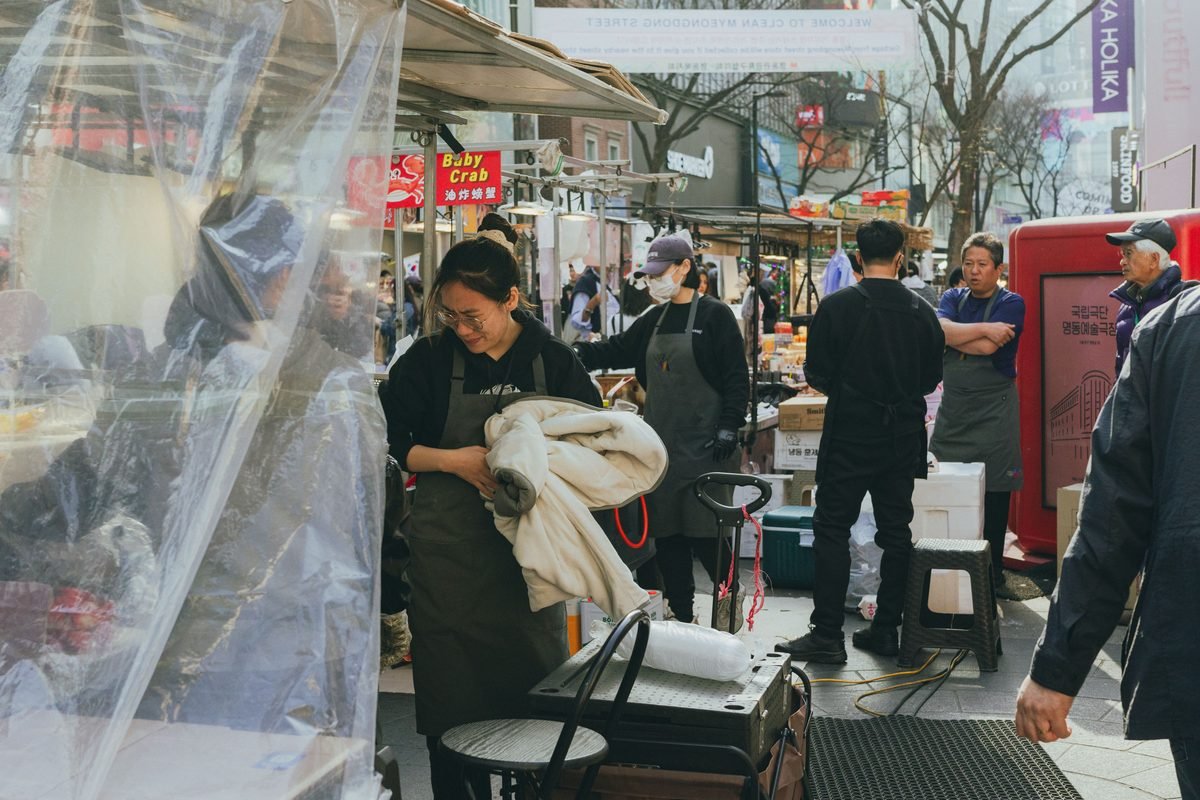 Lively street market scene with food stalls and vendors in Myeongdong Seoul
