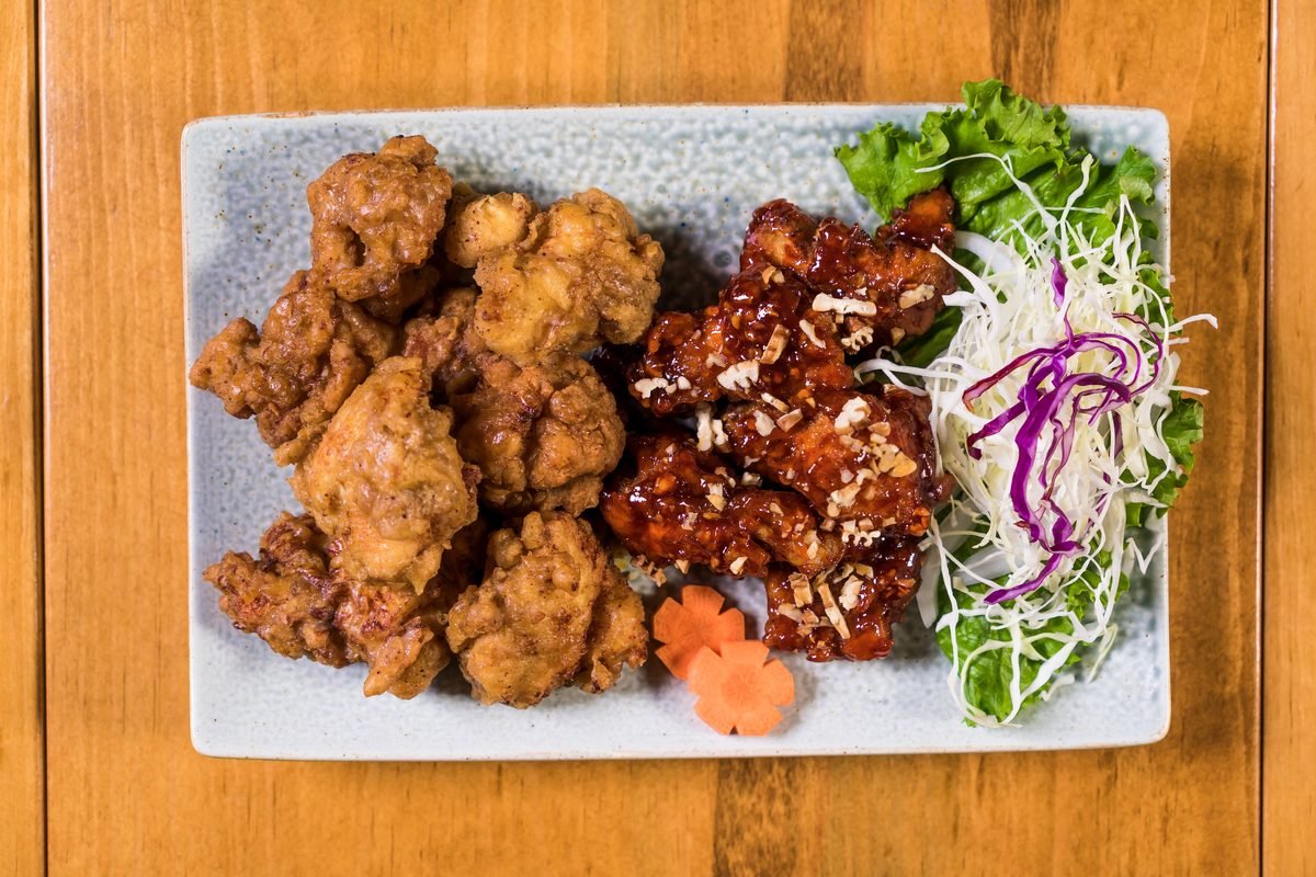 Platter of crispy and glazed Korean fried chicken with fresh salad.