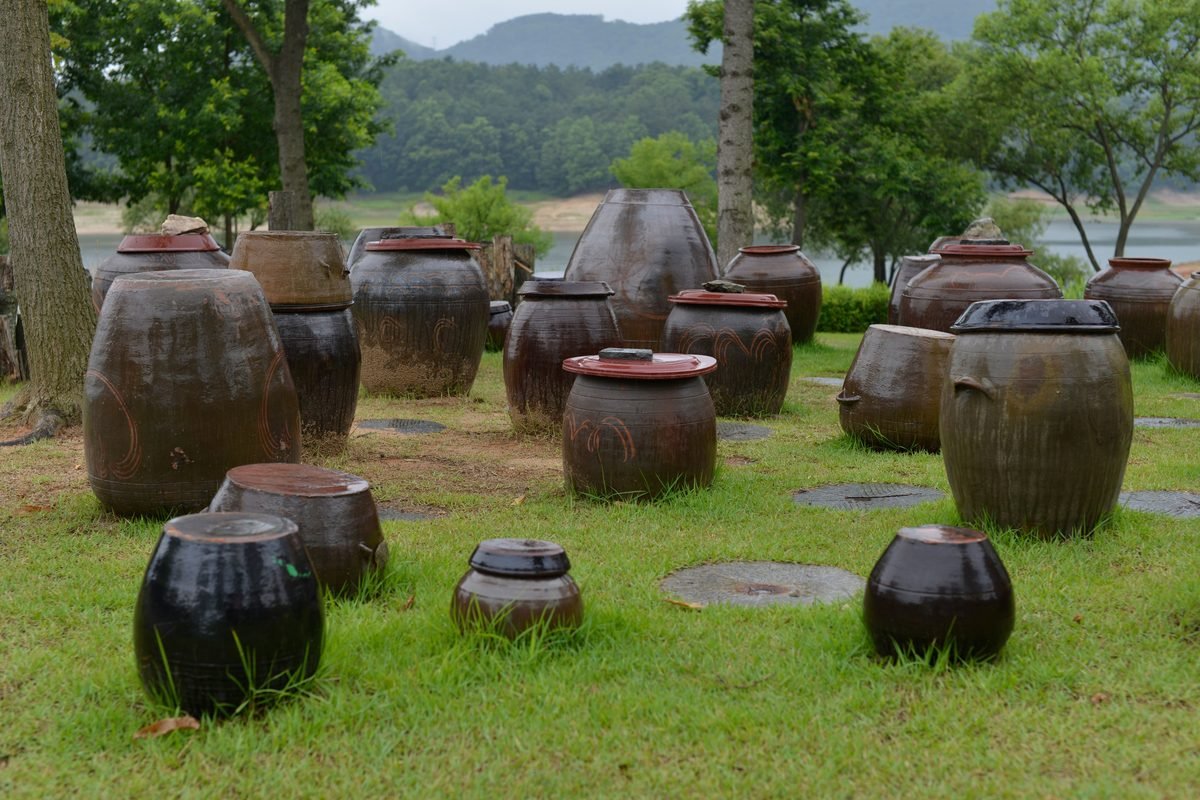 Traditional Korean onggi earthenware jars arranged in a lush garden.