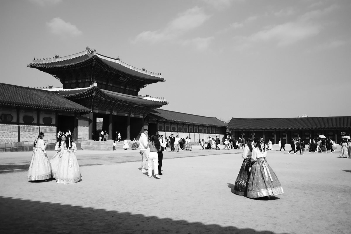 People in traditional clothing near a historic temple in Seoul