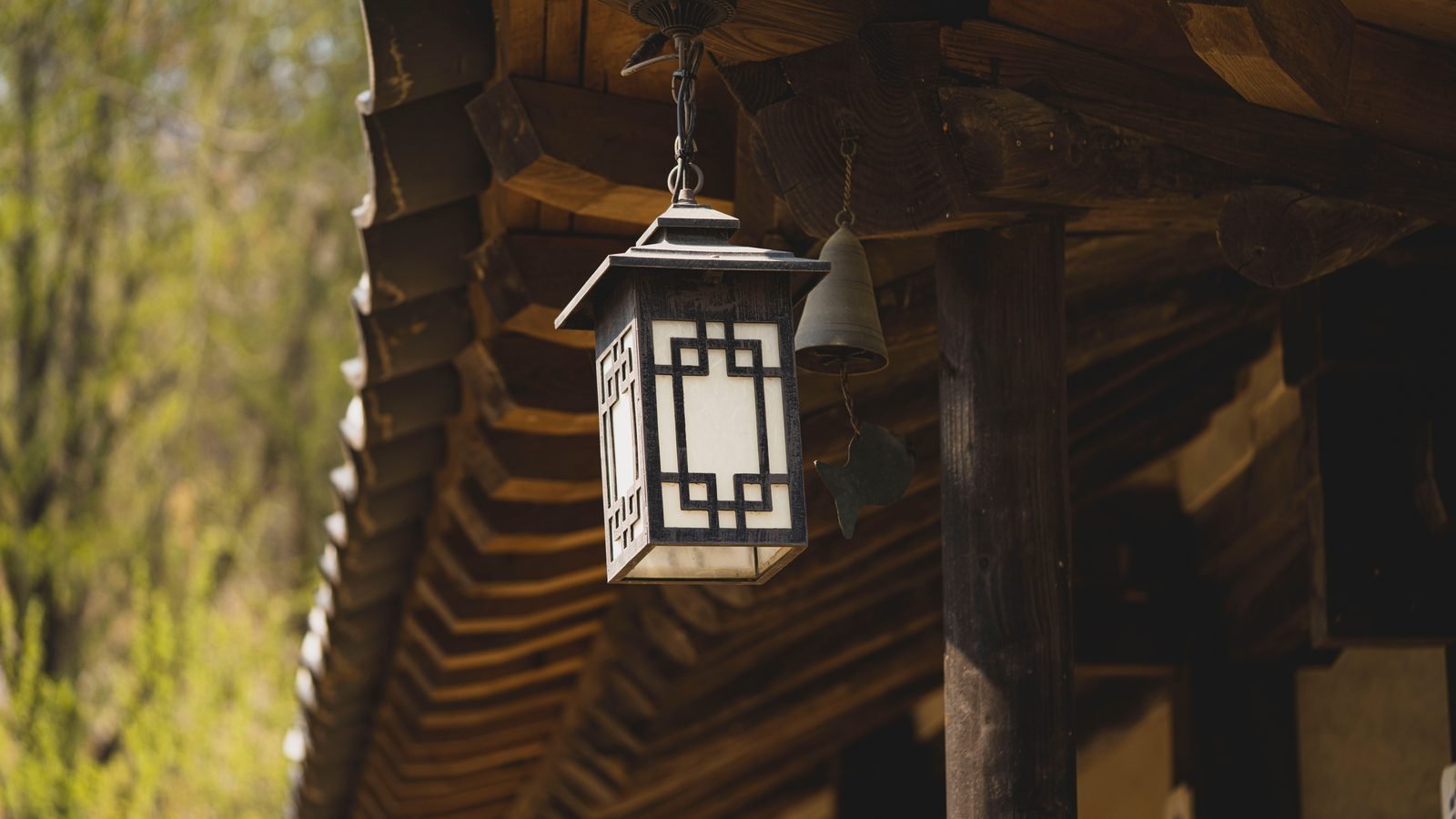 Rustic wooden lantern hanging under eaves of traditional architecture