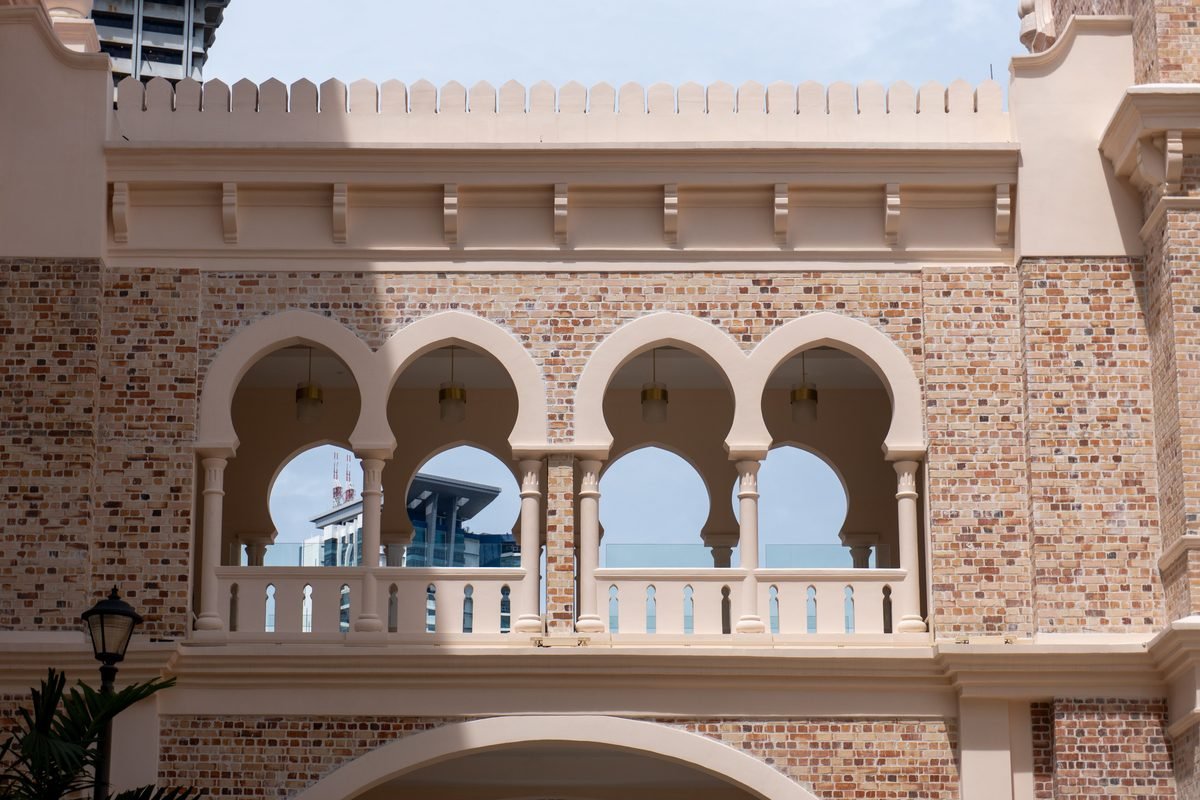 Close-up of ornate Islamic arches framing a modern city building