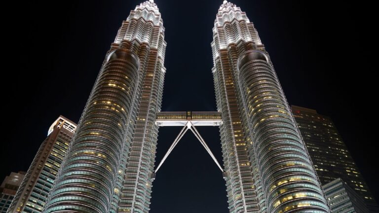 Magnificent upward view of the illuminated Petronas Twin Towers at night in Kuala Lumpur