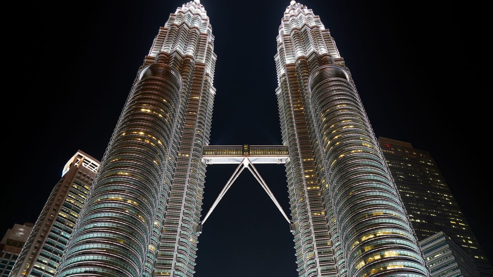 Magnificent upward view of the illuminated Petronas Twin Towers at night in Kuala Lumpur
