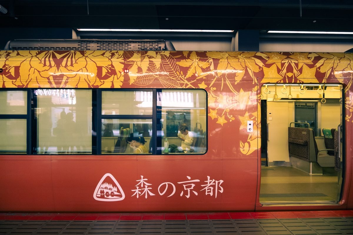 Kyoto metro train with botanical patterns at a station platform.