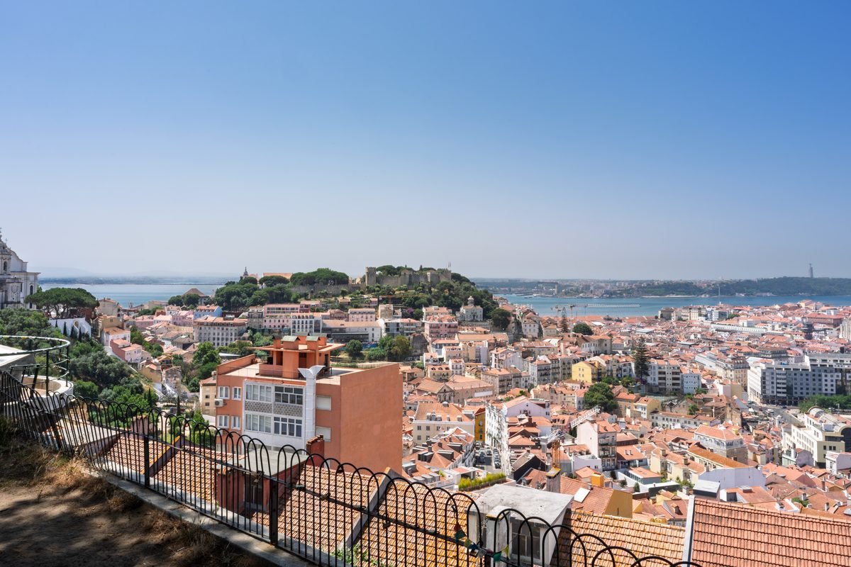Wide panoramic view of Lisbon from Miradouro da Senhora do Monte showcasing the castle hill.