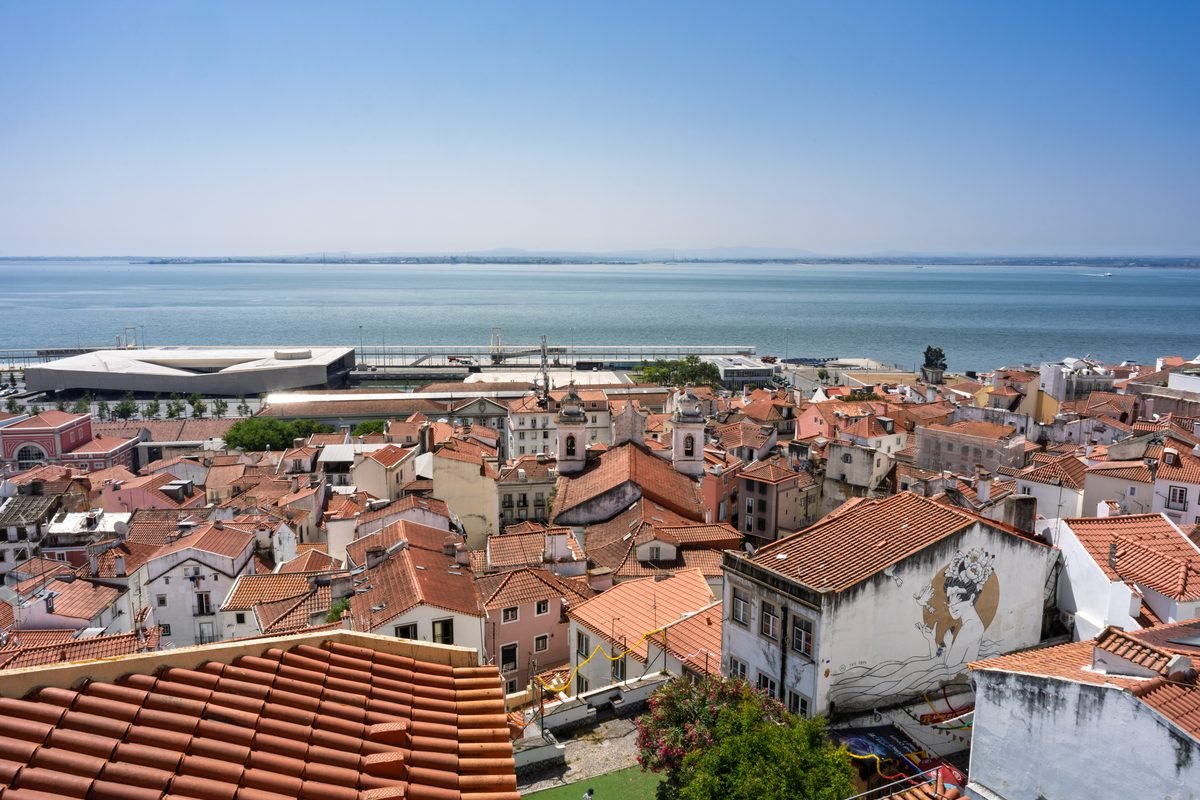 Rooftops of Alfama leading to the waterfront in Lisbon on a clear sunny day.