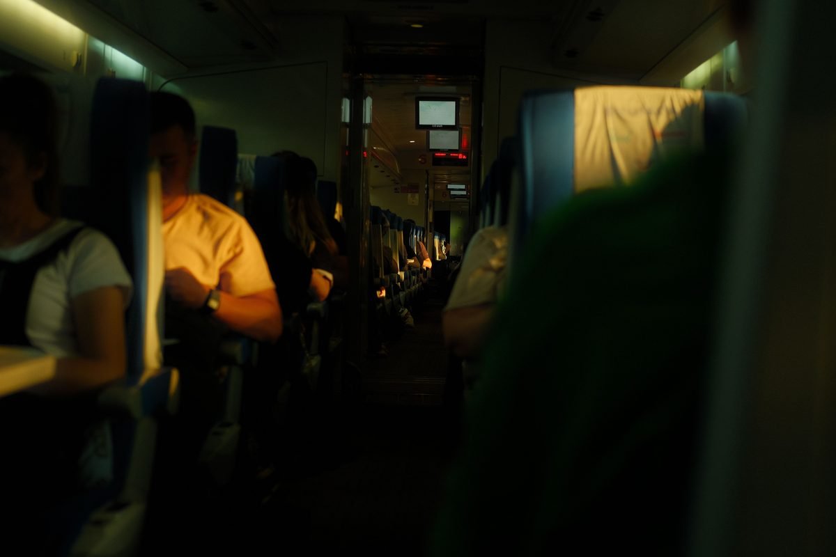Cozy interior view of an airplane cabin with passengers relaxing during flight.