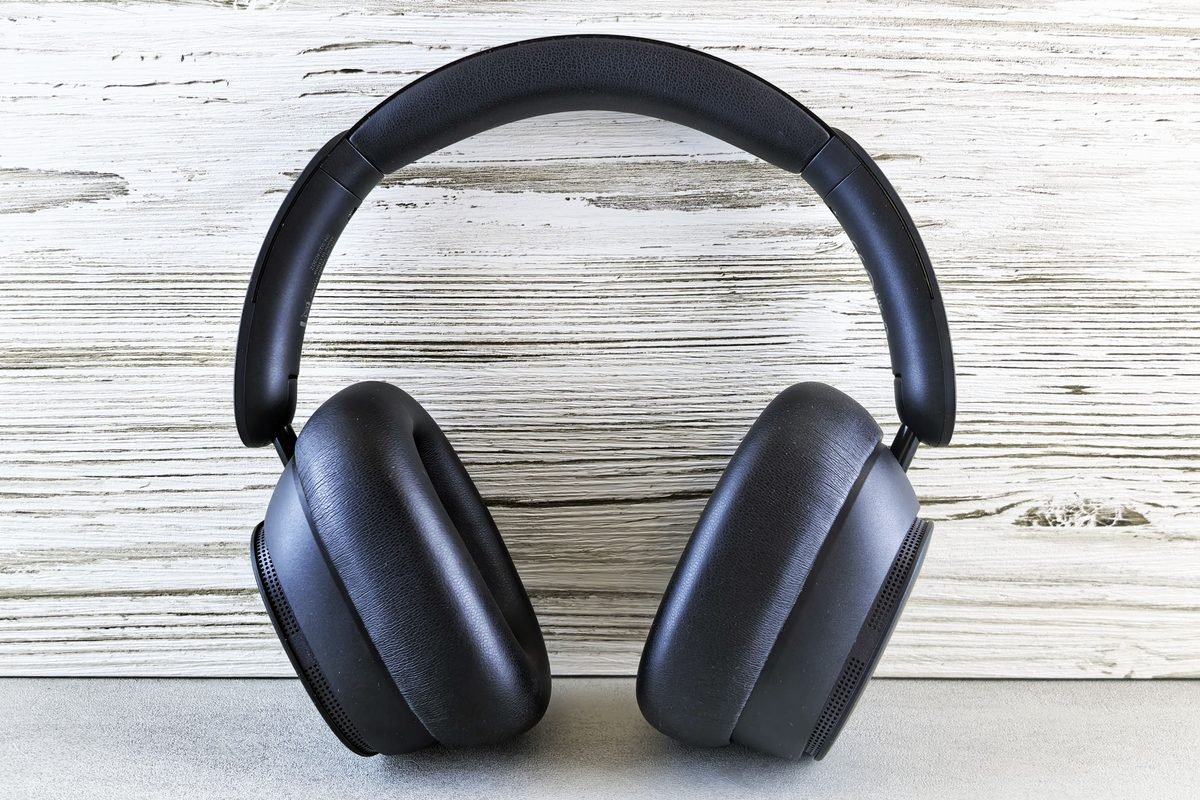 Stylish black over-ear headphones against a wooden textured background.