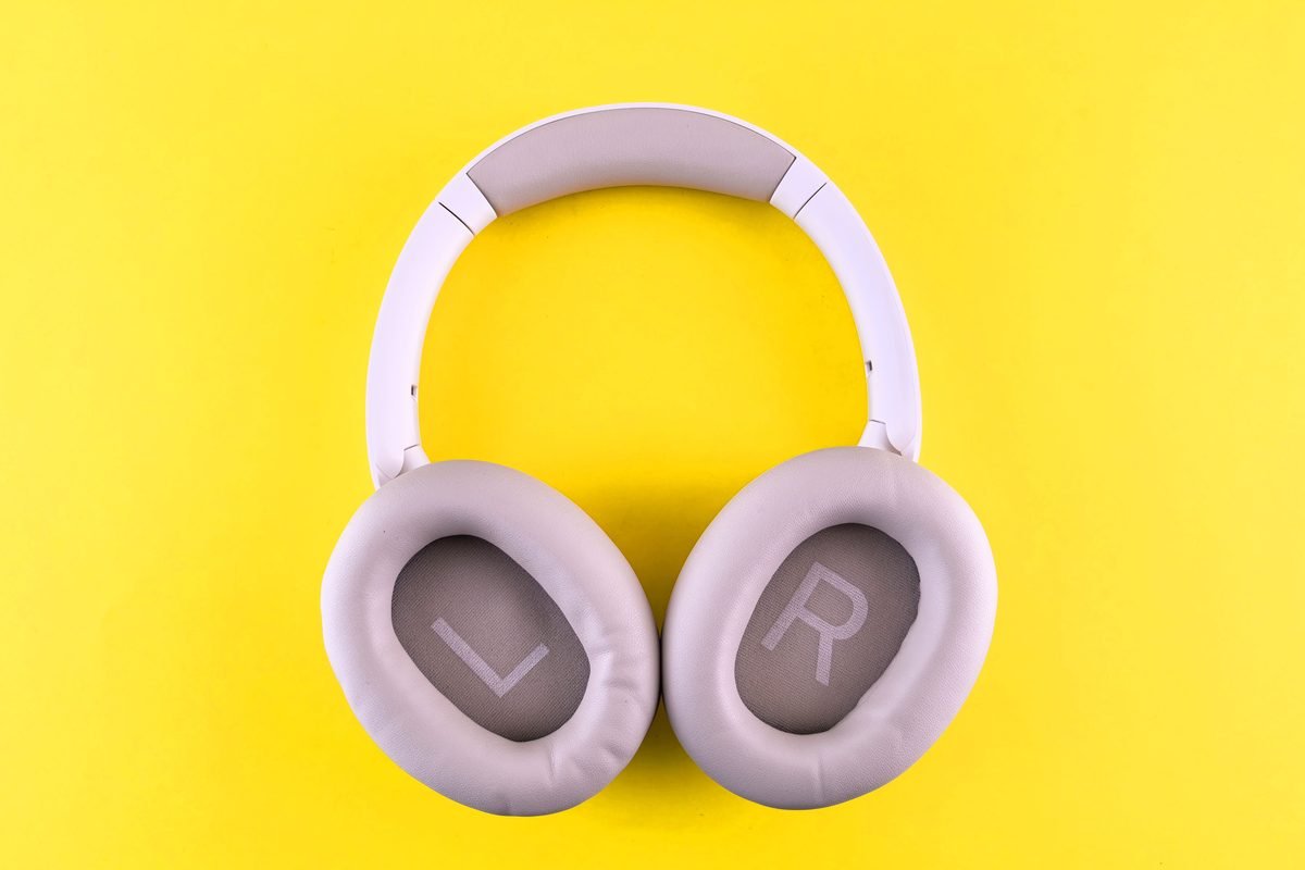 Stylish wireless headphones on a vibrant yellow surface.