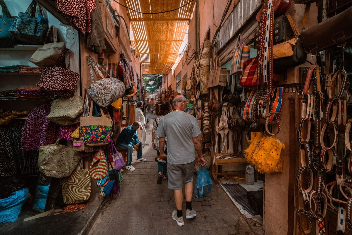 Bustling souk alleyway with colorful textiles and local crafts in Marrakech