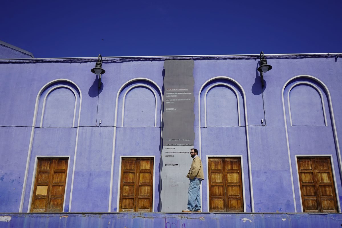 Man standing in front of a bright blue building