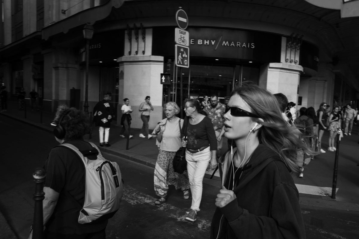 Black and white busy Paris street scene with pedestrians walking past