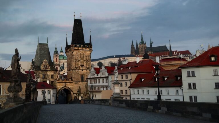Stone towers and historical architecture of Charles Bridge in Prague at dawn