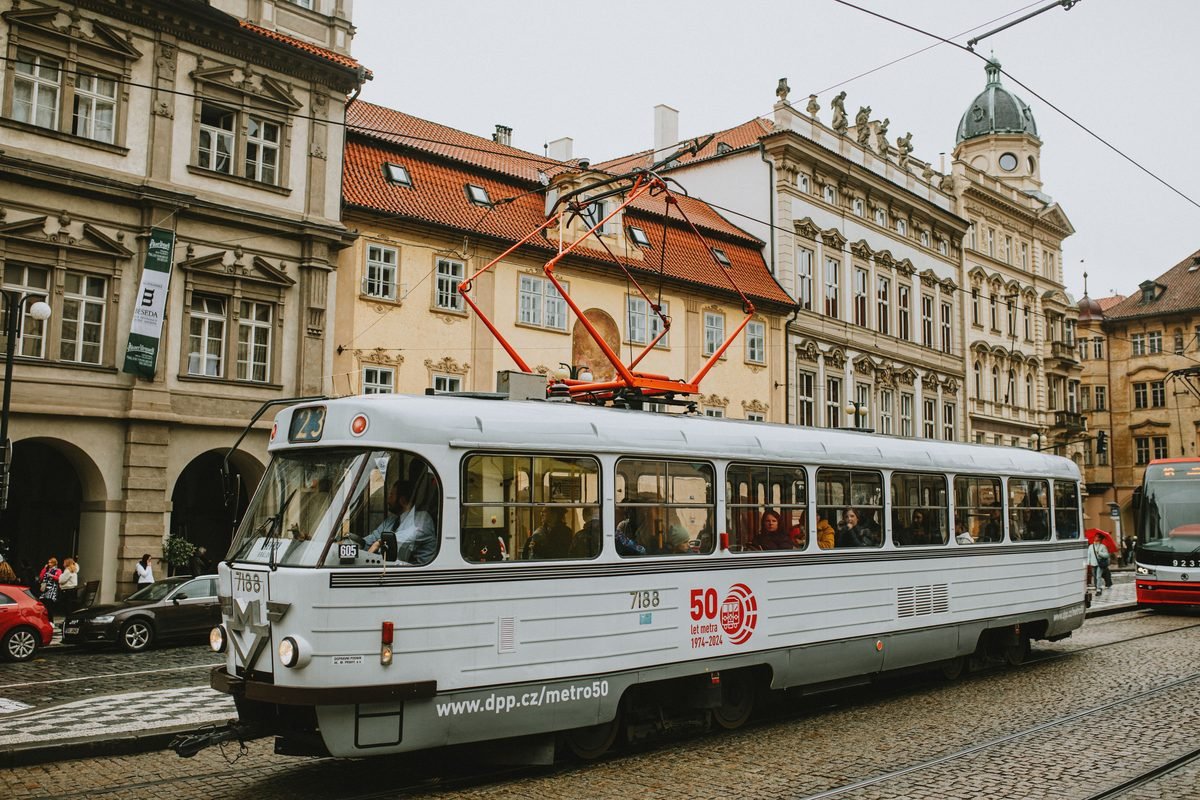 Classic red and white Prague tram rolling down a cobblestone street
