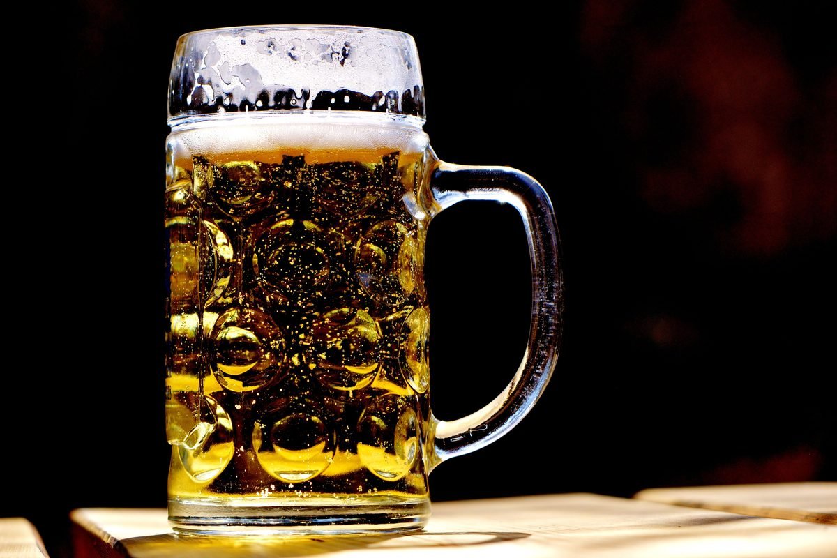 Traditional dimpled beer mug filled with golden lager and rich foam