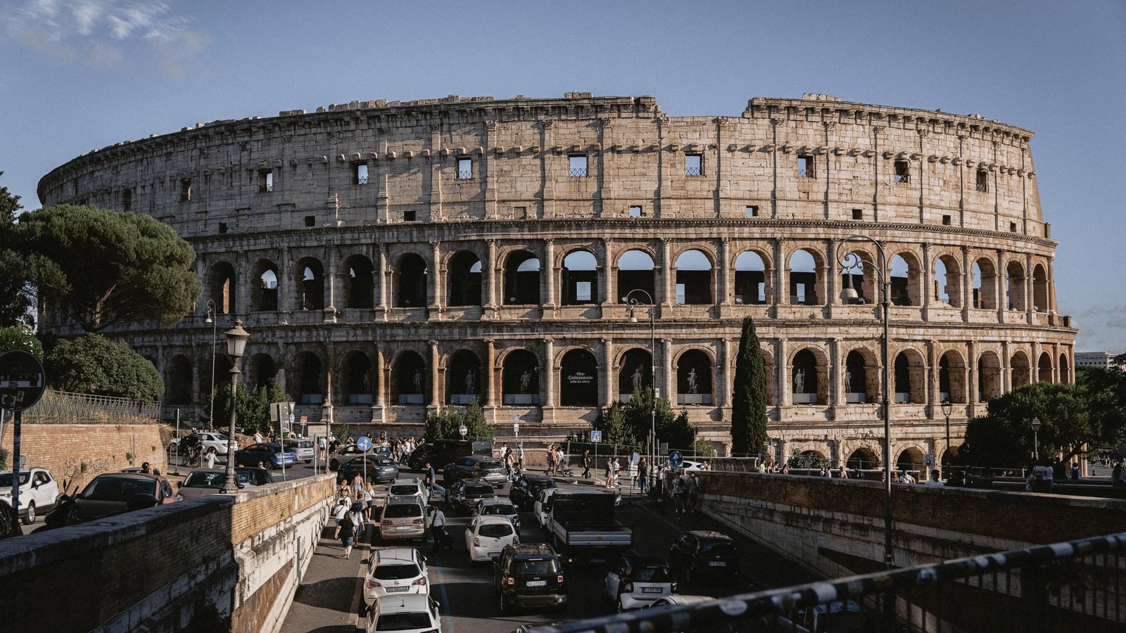 The iconic Colosseum stands majestically under a clear blue sky in Rome.
