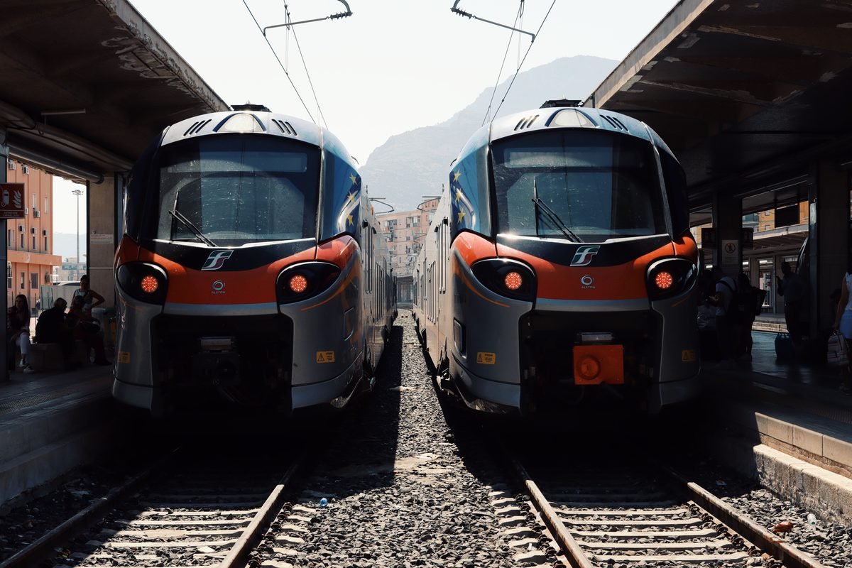 Two modern silver and red trains stopped at a station platform