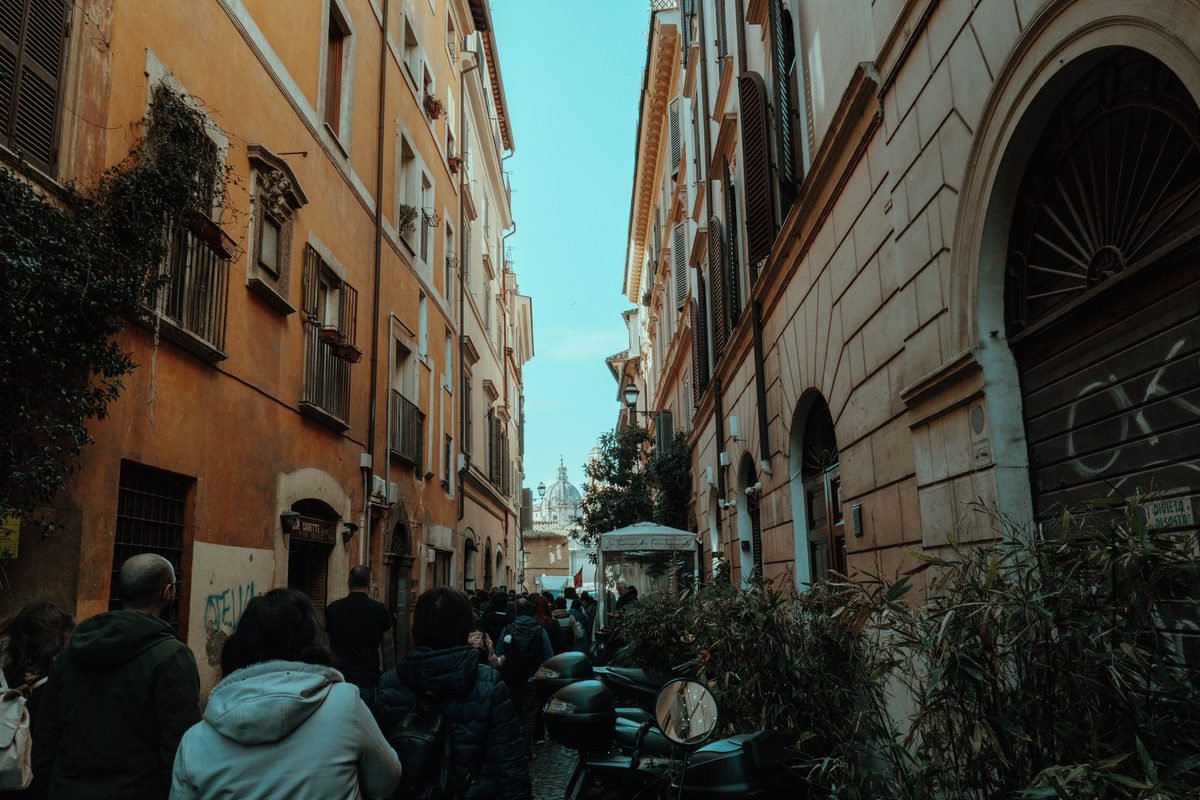 Narrow historic street lined with traditional buildings in Rome.