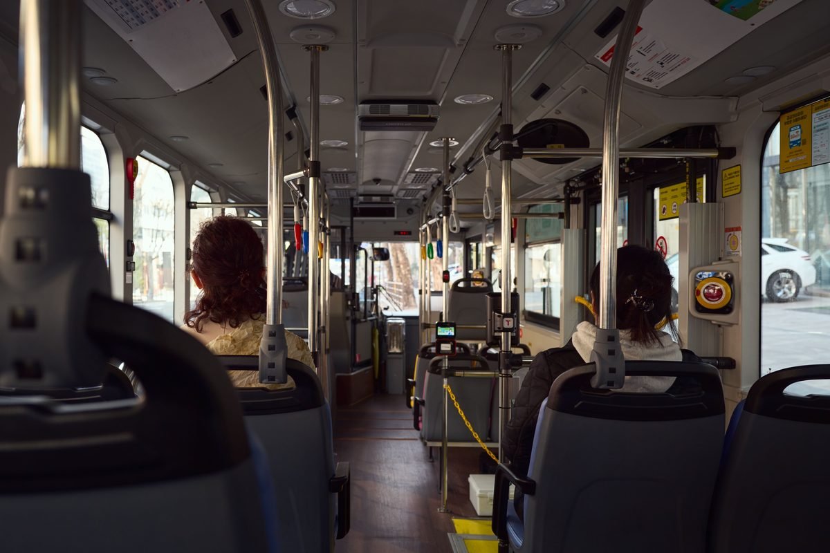 Interior view of a public bus with seated passengers.