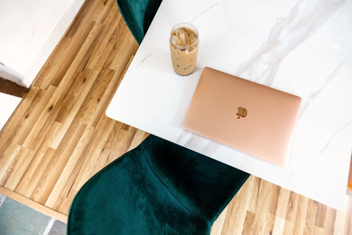 A top view of a contemporary workspace with a laptop and iced coffee.