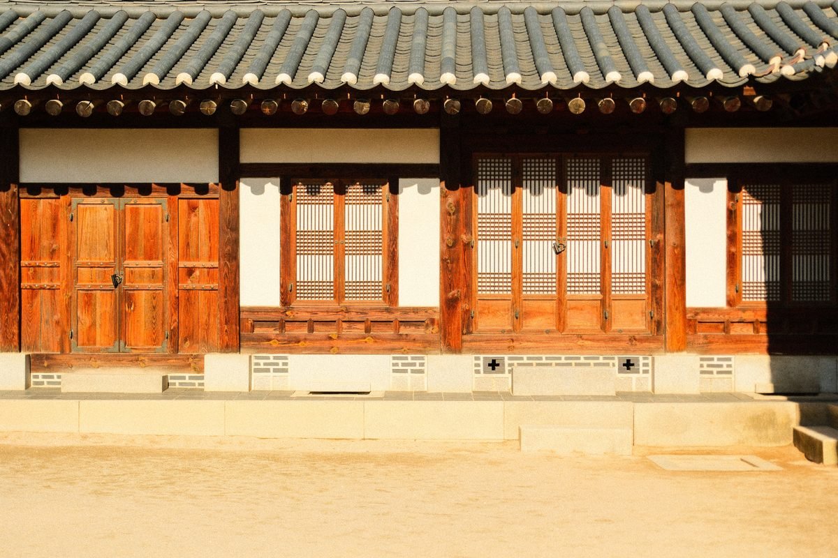 Front view of a traditional Korean hanok house with wooden doors and tiled roof.