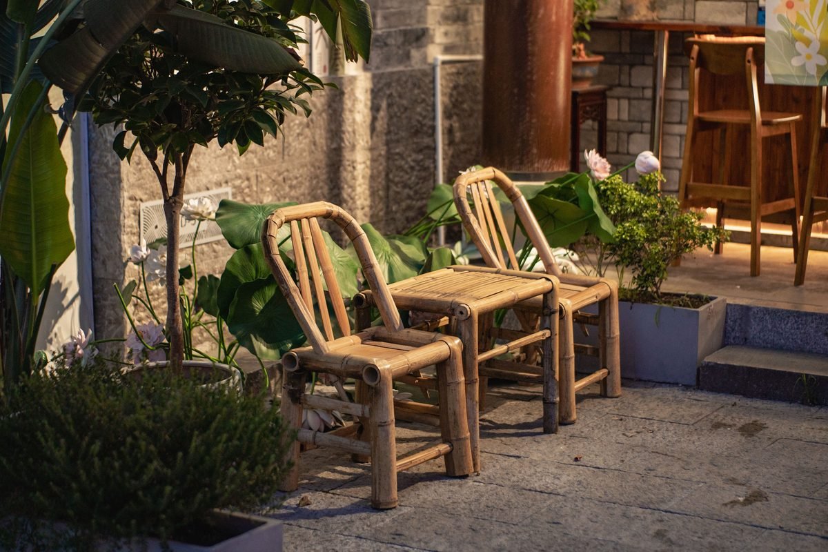 Charming bamboo chairs and table in a serene outdoor garden setting.