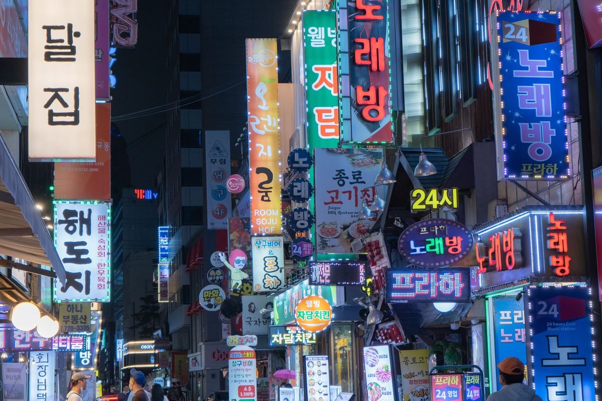 Bustling night scene of Myeongdong with neon signs and vibrant city lights in Seoul.