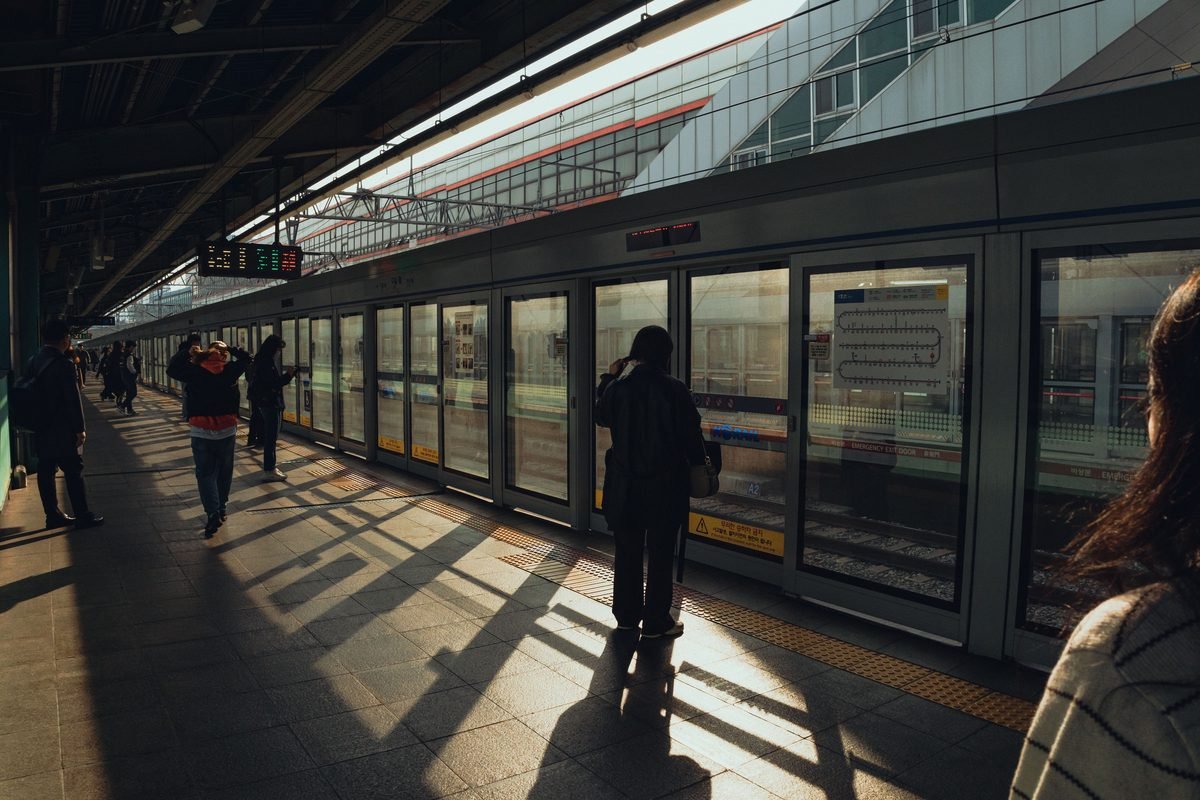 Commuters waiting on a subway station platform in Seoul.