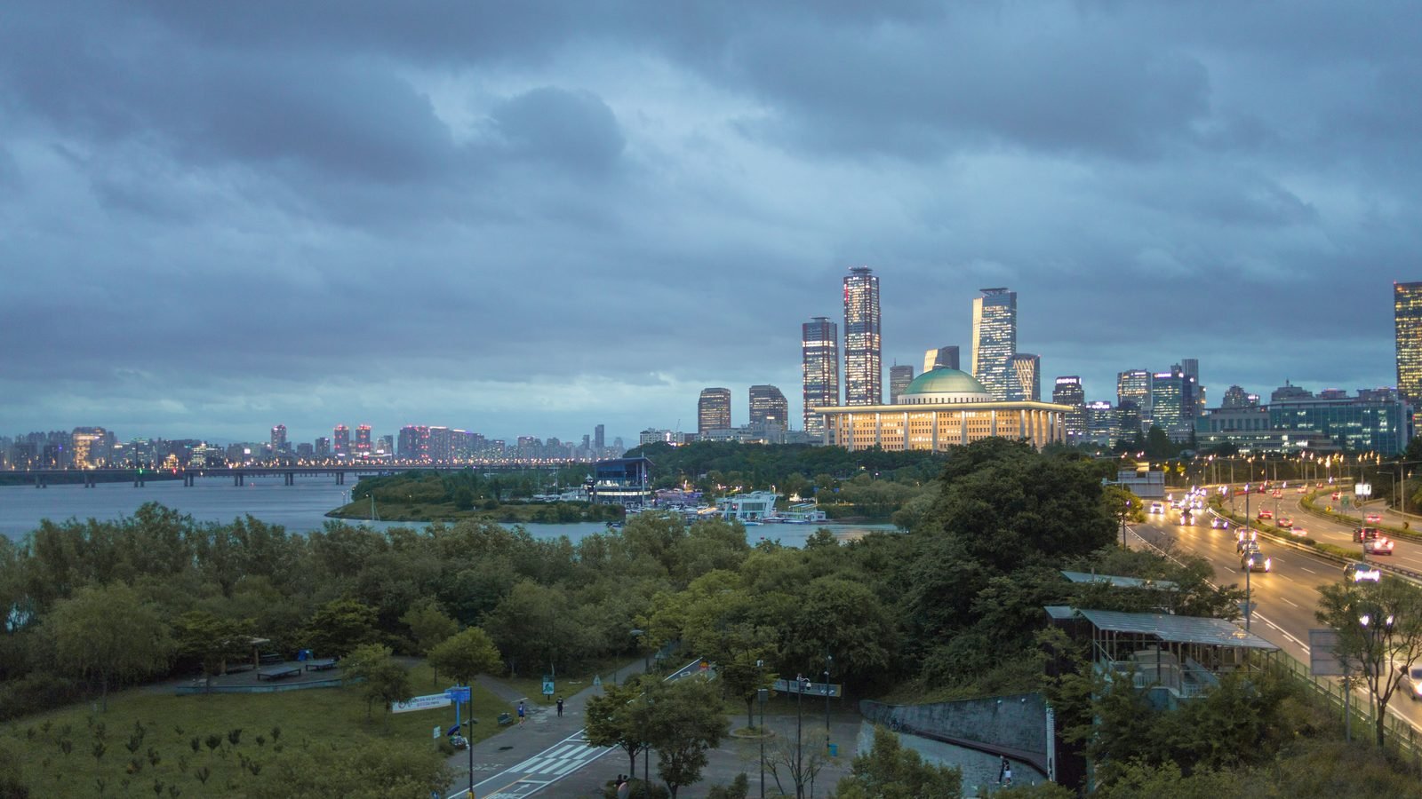 Han River and Seoul skyline under a dramatic sunset sky.