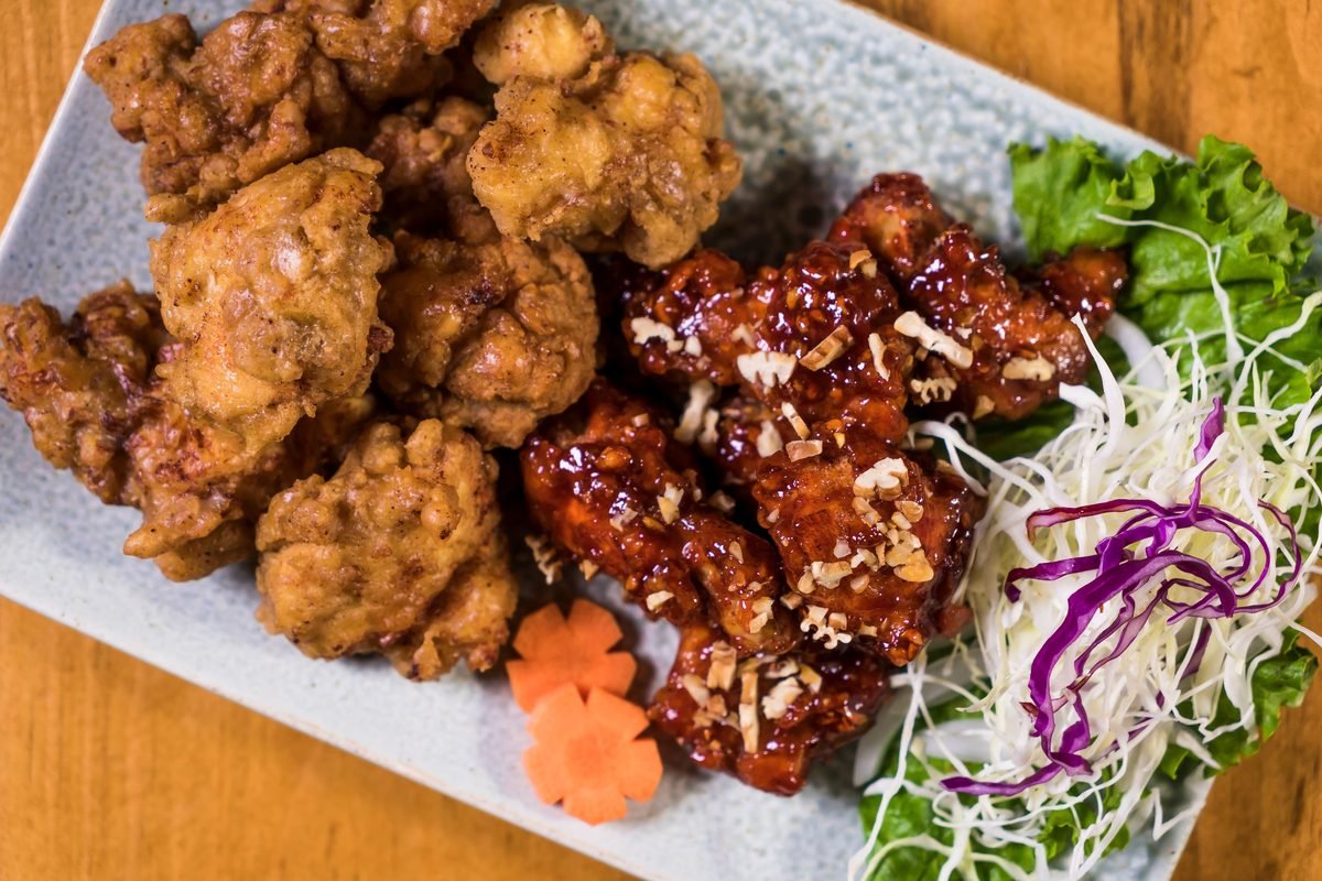 Korean fried chicken served with salad and garnishes.