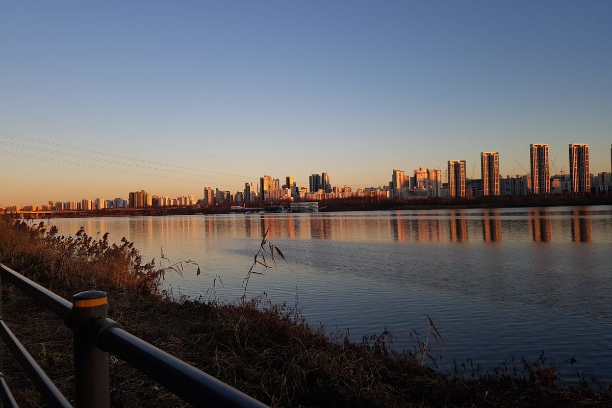 Seocho-gu skyline along the Han River at sunset.