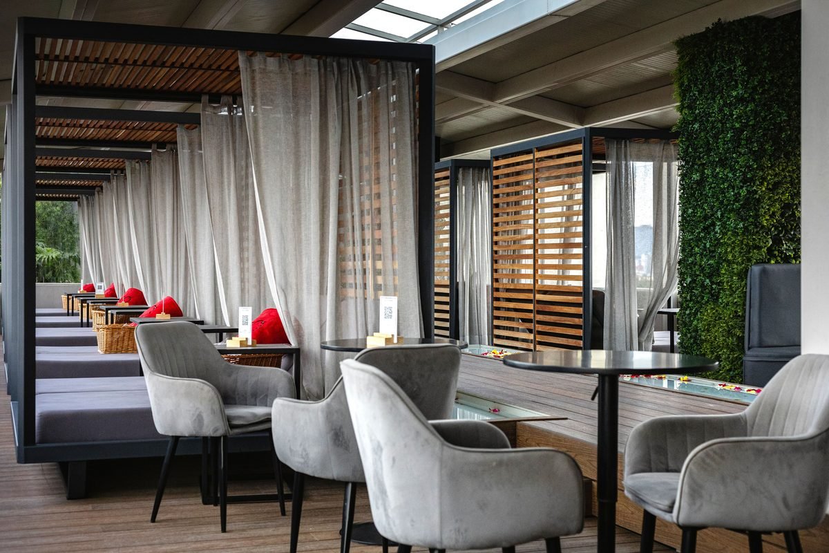 Elegant indoor lounge featuring curtained cabana seating and plush chairs