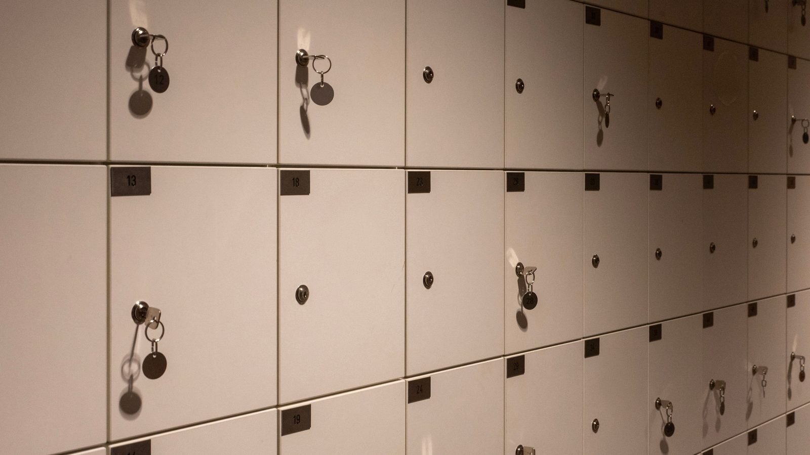 Close-up perspective of numbered white lockers with hanging keys