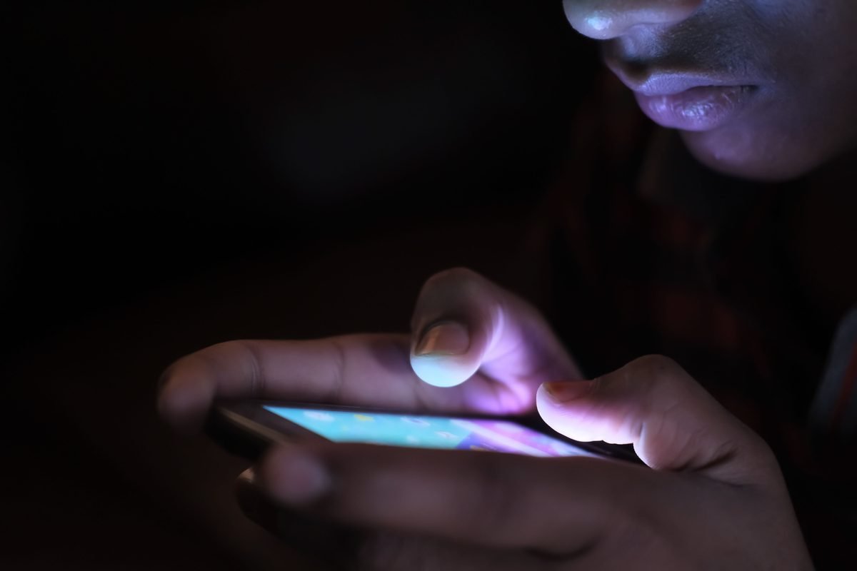 Close-up of a person holding an illuminated smartphone.