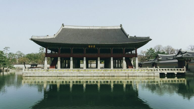 Scenic view of Gyeongbokgung Palace pavilion reflecting in calm water during spring in Seoul, South Korea.