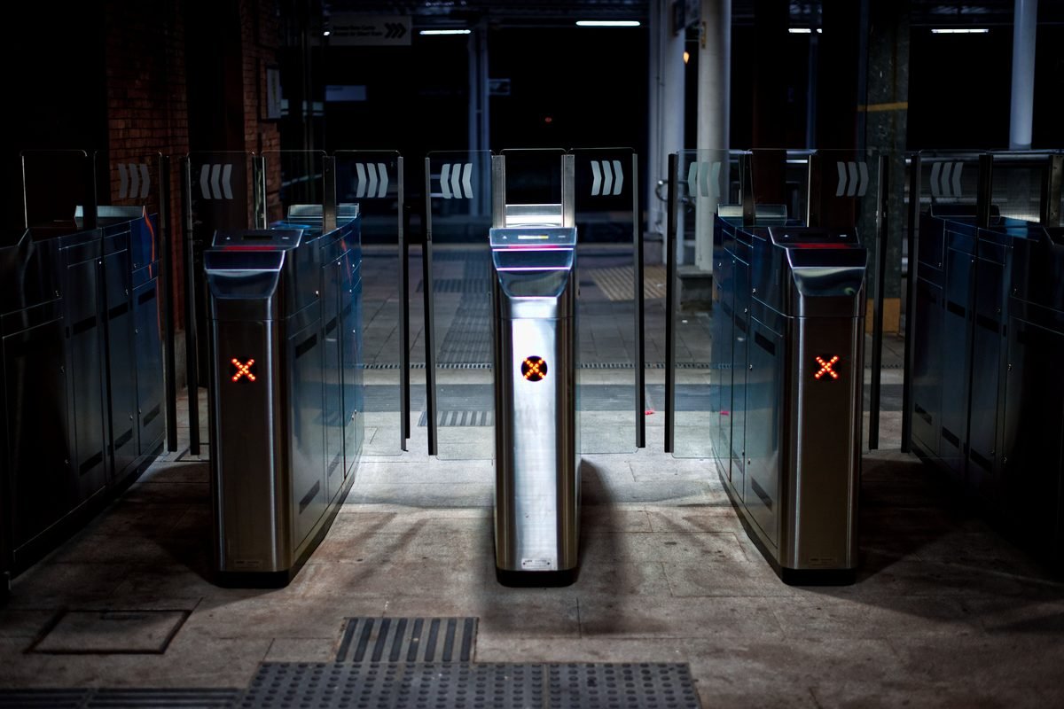 Modern subway turnstiles illuminated at night in a clean transit station.